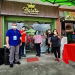 Men and women standing in front of Harito Food Products store