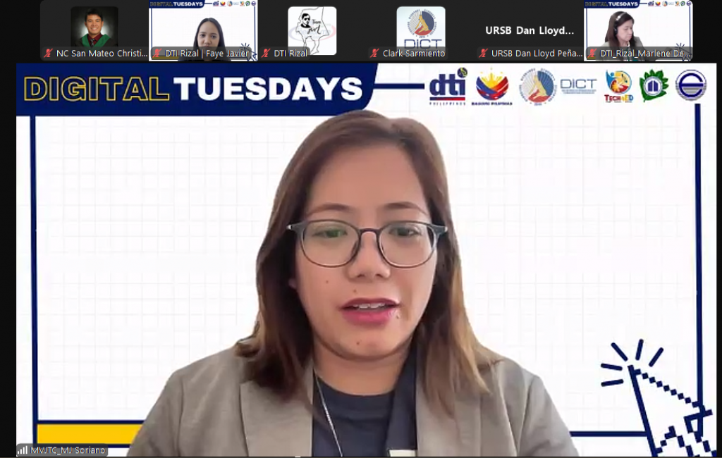 A screenshot of a Zoom meeting showing a woman with glasses and a gray blazer speaking. The Zoom interface displays "DIGITAL TUESDAYS" and logos for "dti" and "DICT".