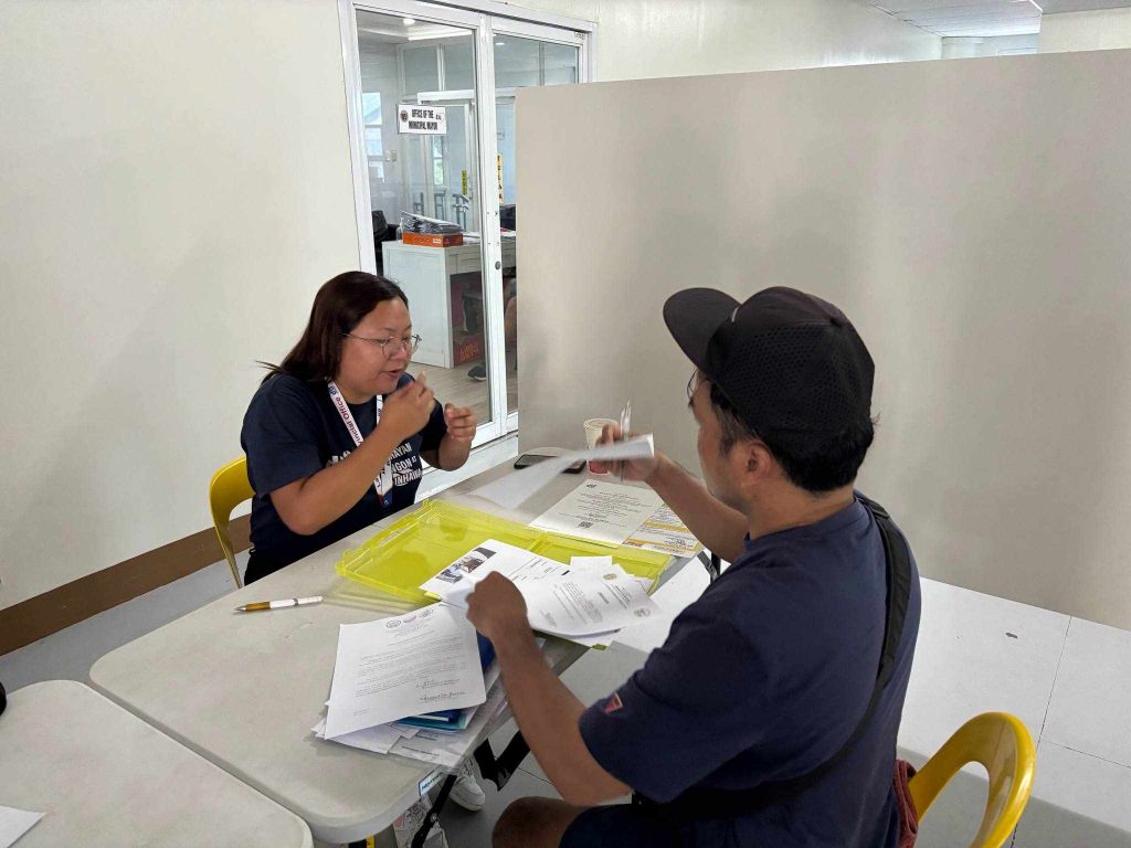 DTI-Laguna personnel conducting profiling and validation interviews with fire-affected vendors at the Santa Cruz Municipal Auditorium under the Pangkabuhayan sa Pagbangon at Ginhawa (PPG) Program.