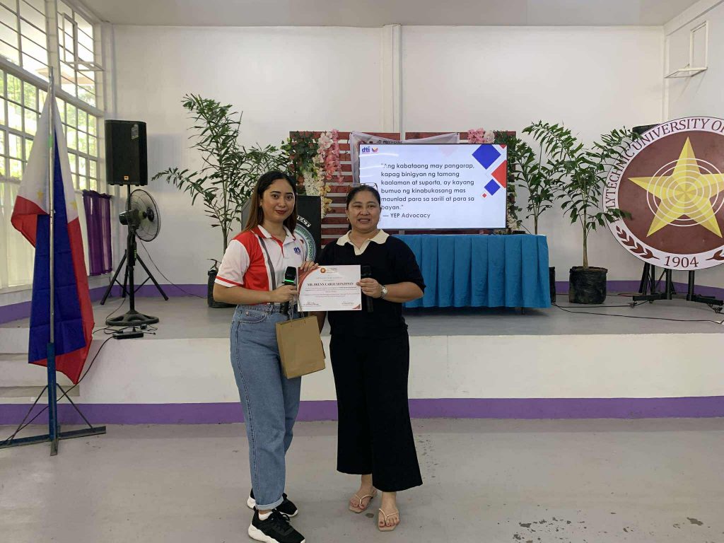 DTI-Laguna representatives presenting entrepreneurship programs to graduating students during the PUP-Calauan career deployment forum, highlighting support services like YEP, Negosyo Center, and SMERA.

