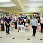 A group photo of DTI staff with the beneficiaries. They are all wearing masks and are standing far apart.