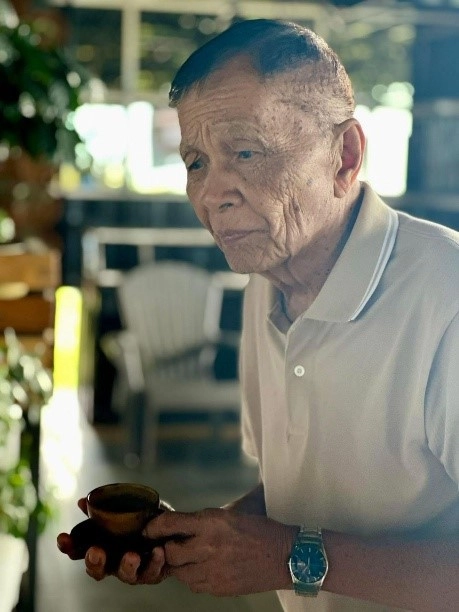 A Misamis Oriental farmer holding a cup of coffee, honored at the Philippine Coffee Quality Competition 2025.