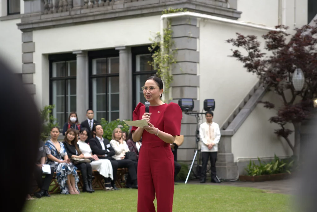 DTI Secretary Cristina Roque speaks at an outdoor event at The Kudan, the official residence of the Philippine Ambassador to Japan, during the Philippine Fashion Showcase featuring Paul Cabral’s ‘Filipino Elegance’ collection.