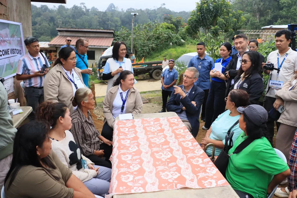 IFAD Associate Vice President Donal Brown and DTI officials engage with coffee farmers and community members in Bukidnon during a site visit under the RAPID Growth Project, highlighting inclusive agro-enterprise development and rural infrastructure improvements.