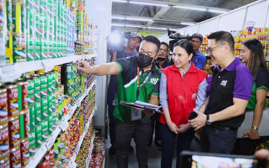 Secretary Ma. Cristina A. Roque and Asec. Atty. Agaton Teodoro O. Uvero of the DTI conducting price monitoring in a grocery store aisle to ensure stability of basic goods amid global geopolitical tensions