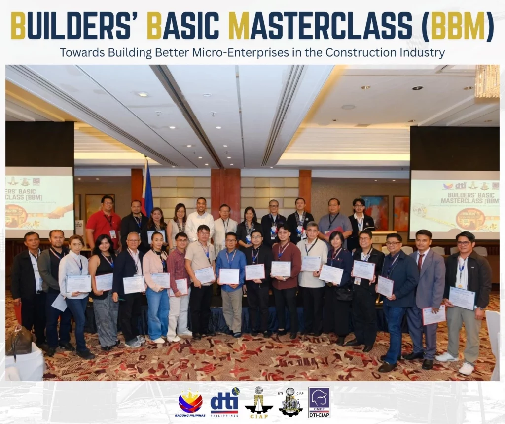 Group photo of participants holding certificates at the Builders' Basic Masterclass (BBM) launch event, themed 'Towards Building Better Micro-Enterprises in the Construction Industry,' held at Shangri-La Makati. Event banners and logos of DTI Philippines, CEAAP, and DTI-CIAP are visible in the background.