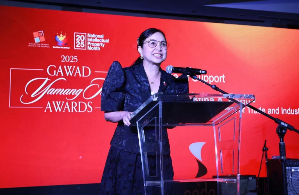 DTI Secretary Cristina A. Roque delivering her speech at the podium during the 2025 Gawad Yamang Isip (GYI) Awards.