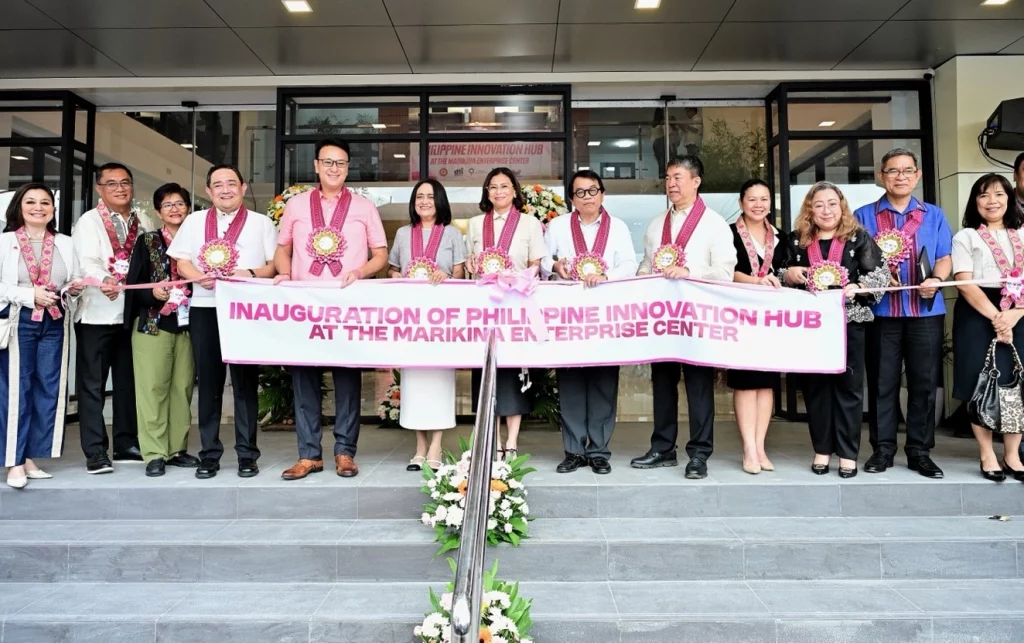 A group of officials and representatives stand in front of the Philippine Innovation Hub at the Marikina Enterprise Center during its inauguration ceremony. They are holding a banner that reads "Inauguration of Philippine Innovation Hub at the Marikina Enterprise Center." The event marks the launch of a new facility aimed at supporting local enterprises and startups.