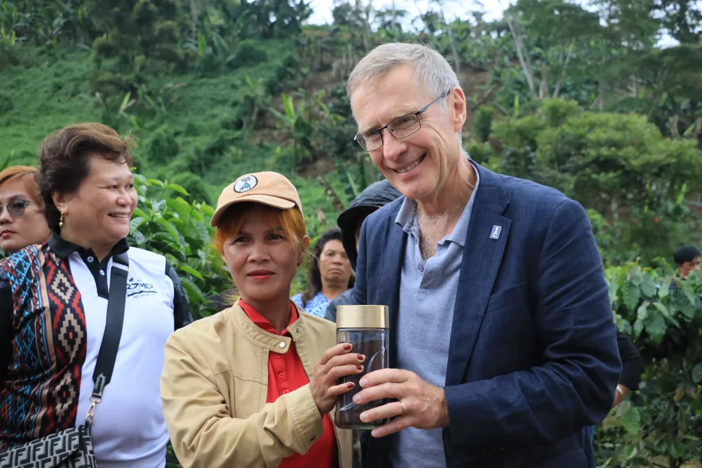 DTI and IFAD representatives observe coffee farming tools and equipment provided through the RAPID Growth Project during a site visit in Bukidnon, highlighting support for rural agro-enterprise development and productivity enhancement.