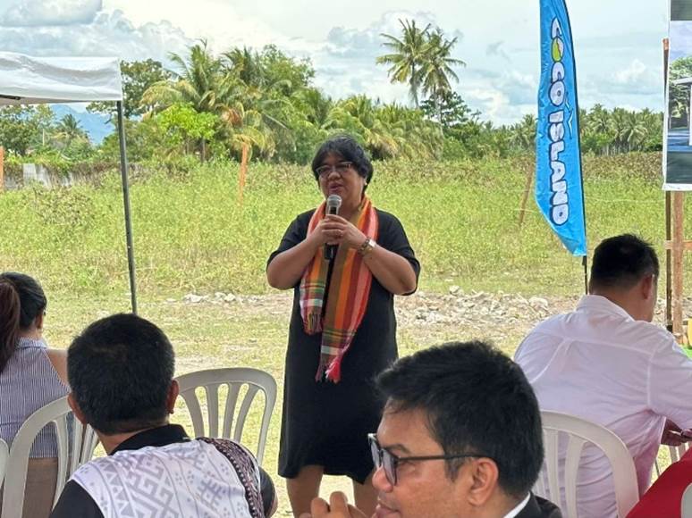 DTI Region 12 Regional Director Flora Gabunales delivering a speech to an audience during the Coco Island groundbreaking ceremony.