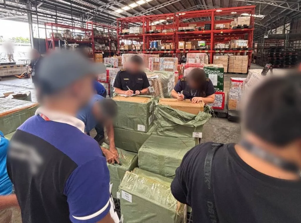 DTI officials inspecting and documenting confiscated illegal vape products displayed on a table, including various colorful packaging and brands seized during enforcement operations in the Philippines.