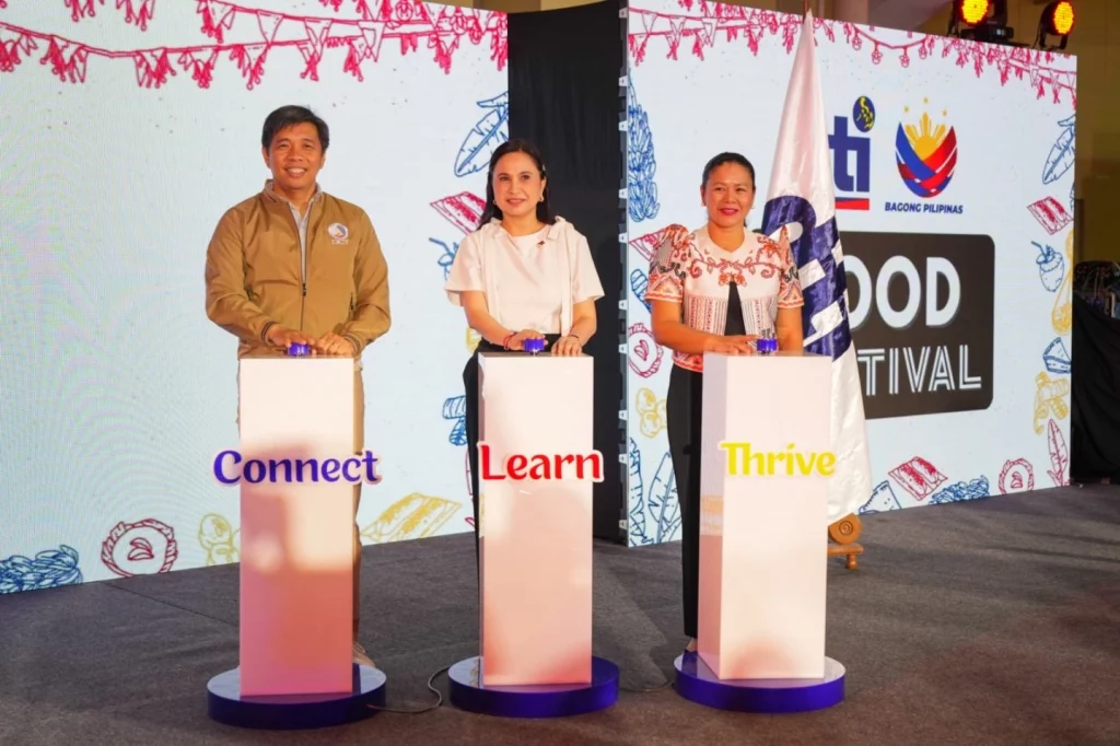 DICT Secretary Henry Aguda, DTI Secretary Ma. Cristina A. Roque, and DTI Assistant Secretary Nylah Rizza D. Bautista press the Connect, Learn, and Thrive buttons on podiums during the official launch of the Malikhaing Pinoy Website, with a FOOD FESTIVAL banner in the background.