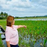 Photo of Lilia Malinao-Galang, owner of LMG Food Products Corporation pointing towards their crops.