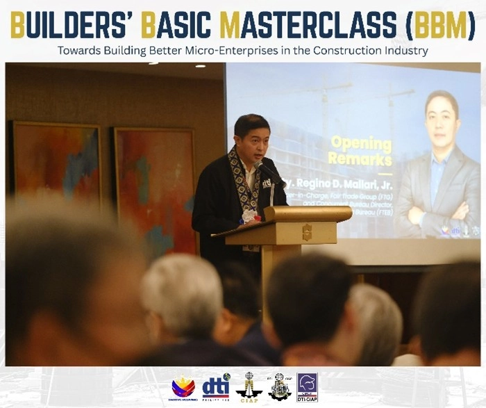 Engr. Regino D. Mallari, Jr., Vice-Chair for Trade Group (PTOA) and Immediate Past President of the Philippine Constructors Association (PCA), delivering opening remarks at the Builders' Basic Masterclass (BBM) event. The theme 'Towards Building Better Micro-Enterprises in the Construction Industry' is displayed on a large screen behind him, along with logos of supporting organizations.