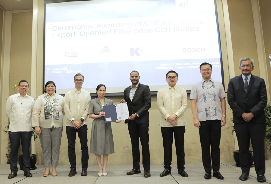 DTI Secretary Cristina Roque, Senator Sherwin Gatchalian, Representative Joey Salceda, and other officials award the Export-Oriented Enterprise (EOE) Certificate to a company representative during the ceremonial awarding under the CREATE MORE Act at Makati Diamond Residences on June 2, 2025, with logos of Dole, Bosch, and other certified companies displayed in the background.