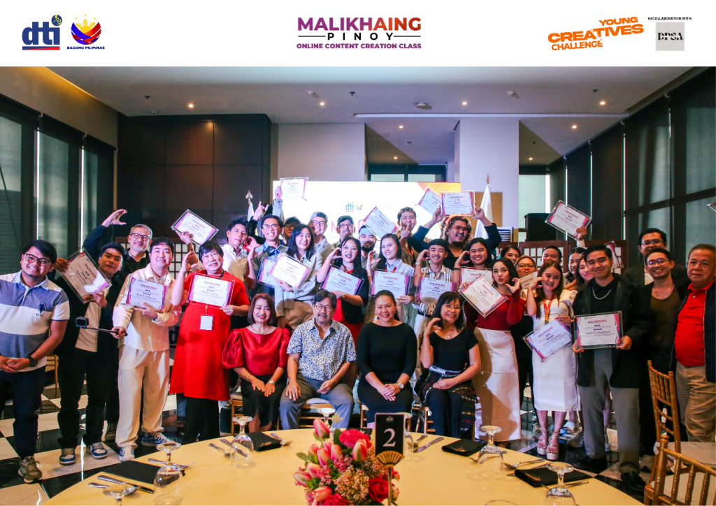 Group photo of Malikhaing Pinoy: Online Content Creation Class scholars and mentors, including Leo Martinez, Raymond Red, Ricky Orellana Jr., Mel Bacani III, Senen Dimaguila Jr., and Jolevs Domingo, holding certificates at the culminating event organized by the Department of Trade and Industry (DTI). Also present are DTI Assistant Secretary Leonila T. Baluyut and Assistant Secretary Nylah Rizza D. Bautista. The initiative highlights Filipino creativity and digital storytelling excellence.