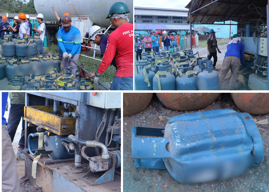 Workers in safety gear dismantle and destroy LPG tanks using tools and hydraulic presses in an industrial setting.