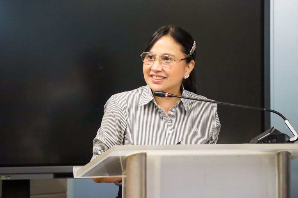 DTI Secretary Ma. Cristina A. Roque speaks at the podium during the MOU signing event with Japan’s rinna Co. Ltd., marking the launch of Project TRINA, the agency’s AI-powered public assistance initiative.