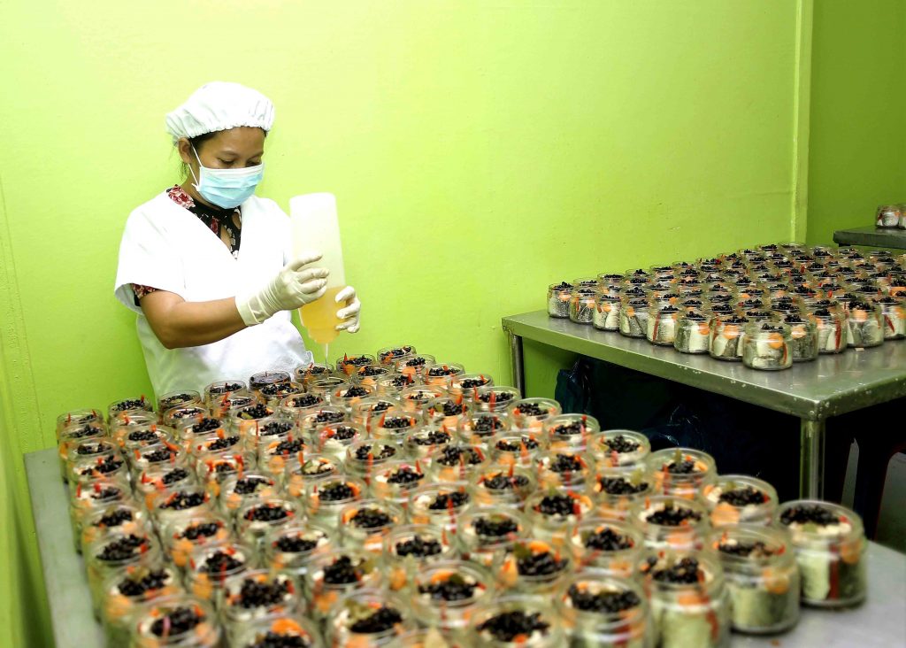 Jida's staff wearing complete safety unifrom while preparing the bottled Bangus products