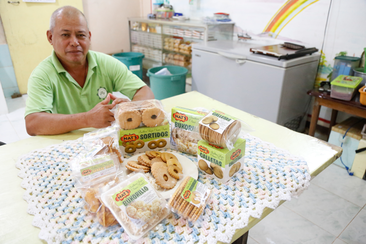 Nathaniel ‘Nat’ Sansan sitting on a table full of their bestsellers