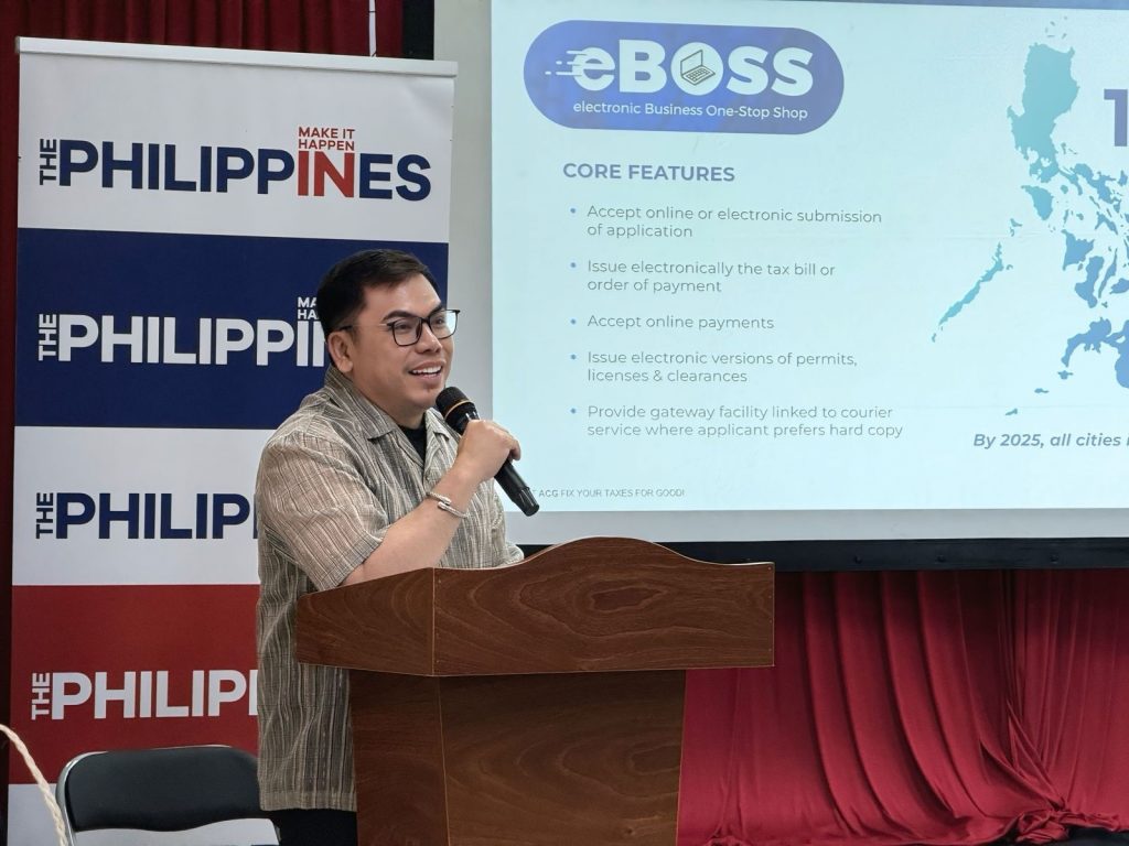 Asian Consulting Group (ACG) CEO Mon Abrea discusses the Philippine’s investment climate at a podium, with a presentation screen behind him highlighting features of the electronic Business One Stop Shop (eBOSS).