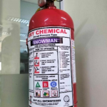 Alt text: A red fire extinguisher sitting on top of a wooden pallet