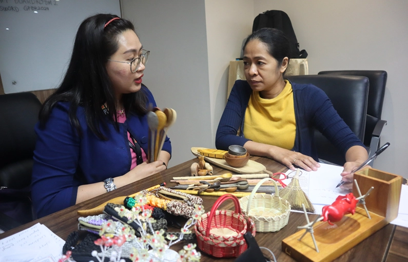 MR. D.I.Y. Philippines representative Ms. Rosemarie Jaspe engages in a business matching session with Cebu-based MSME owner Ms. Jomaima Basmayor. The discussion focuses on locally crafted products, including wooden utensils, handwoven baskets, and fashion accessories. Various handmade items are displayed on the table, showcasing the craftsmanship of Cebuano enterprises. This session is part of the DTI-led initiative to connect local suppliers with international buyers, fostering business opportunities and market expansion.